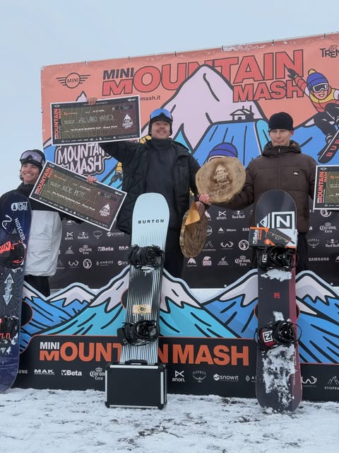 Álvaro y otros snowboarders en un podio con sus tablas.