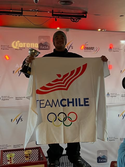 Álvaro sostiene un trofeo y una bandera de Team Chile.