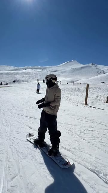 Álvaro con su tabla sobre una pista de nieve.